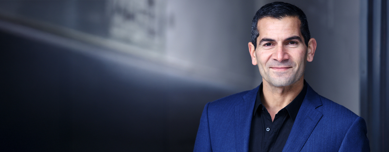 Keynote-Speaker Mitri Sirin vor grauem Hintergrund